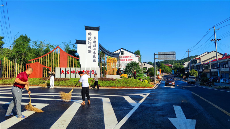 群众在焕然一新的路口打扫卫生.jpg